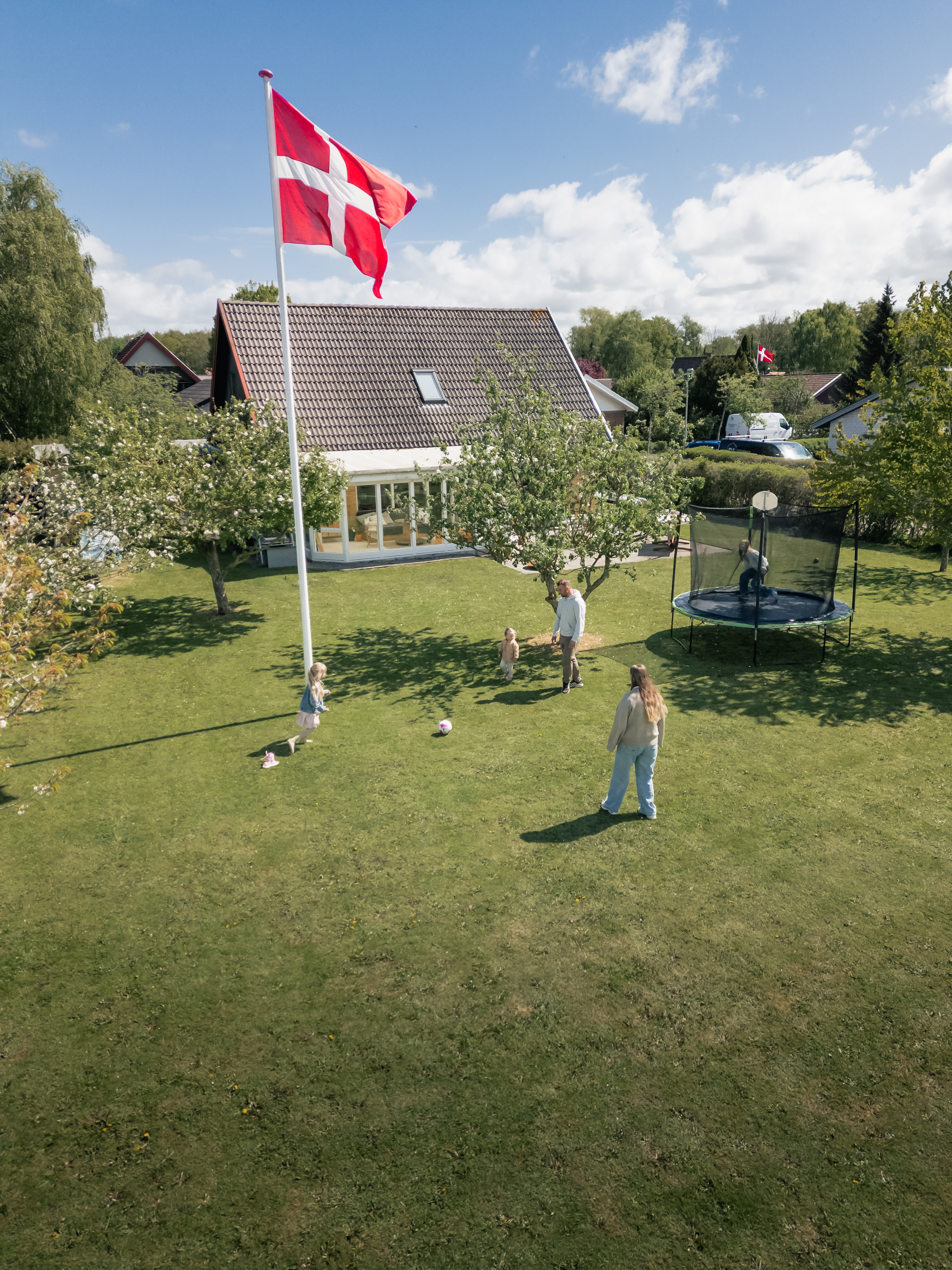 Familie fra Bogense hjemme i deres have og spiller fodbold.
