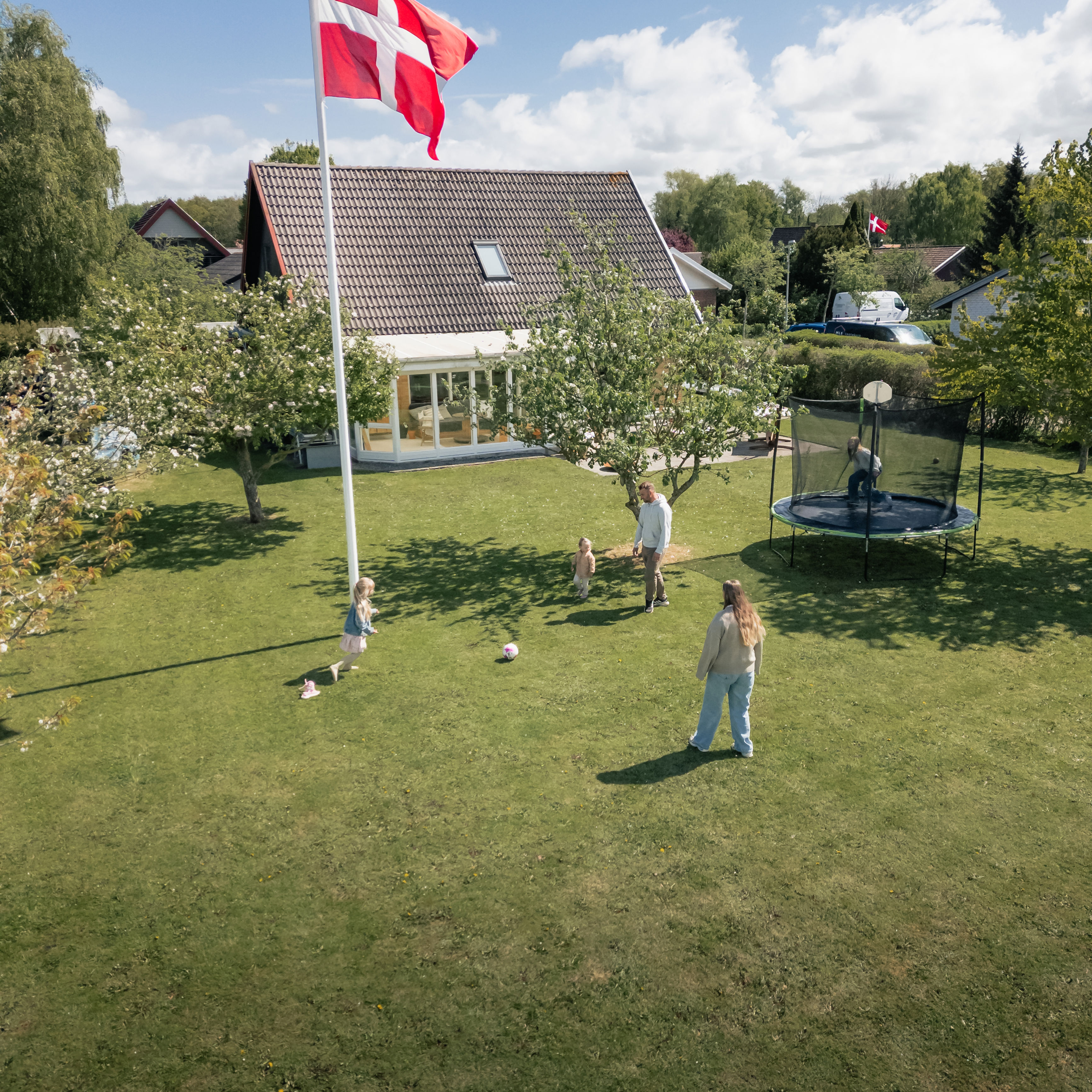 Familie fra Bogense hjemme i deres have og spiller fodbold.