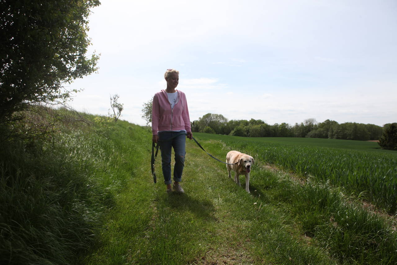 Kvinde, der lufter hund.