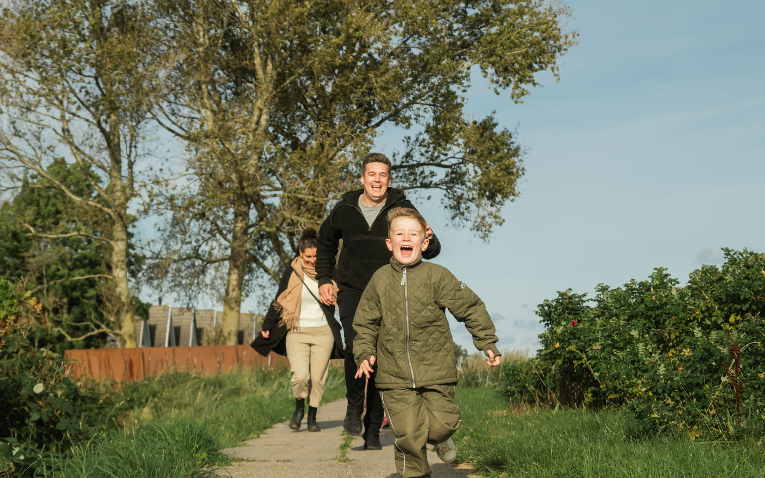 Familie, der løber langs diget ved Hasmark Strandoase
