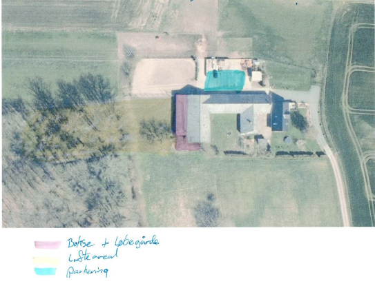 Oversigtsfoto over ejendommen, der viser placering af parkeringsareal, lufteareal, samt placering af bokse og løbegård.