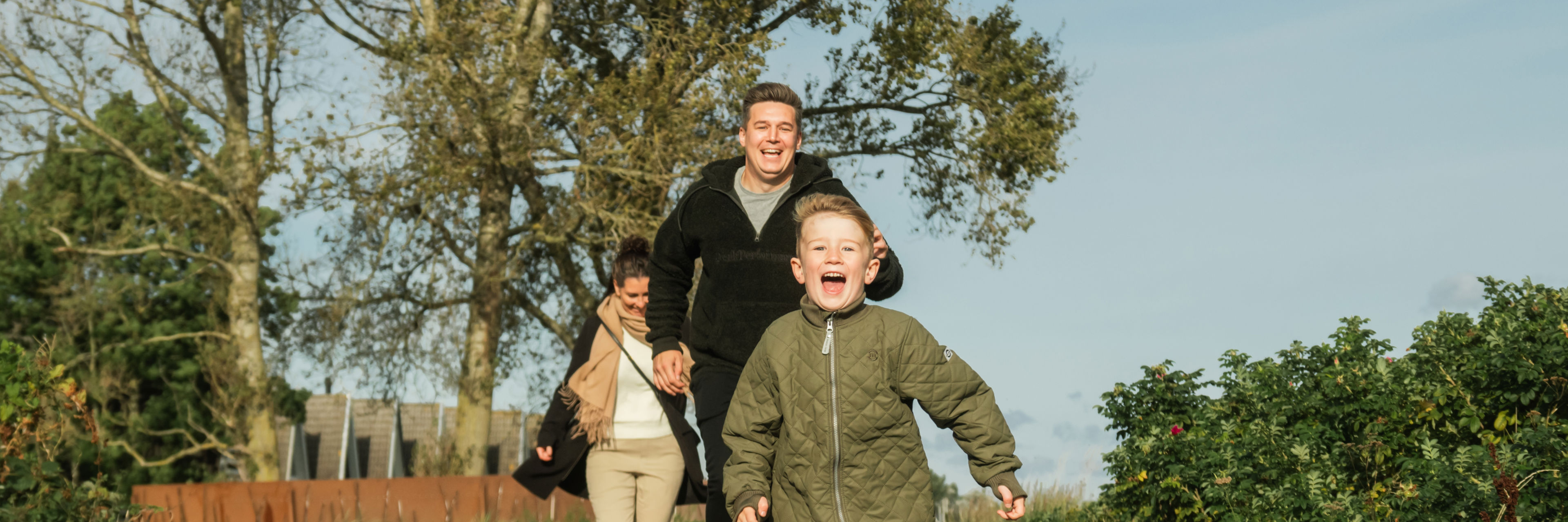 Familie med barn løber på sti