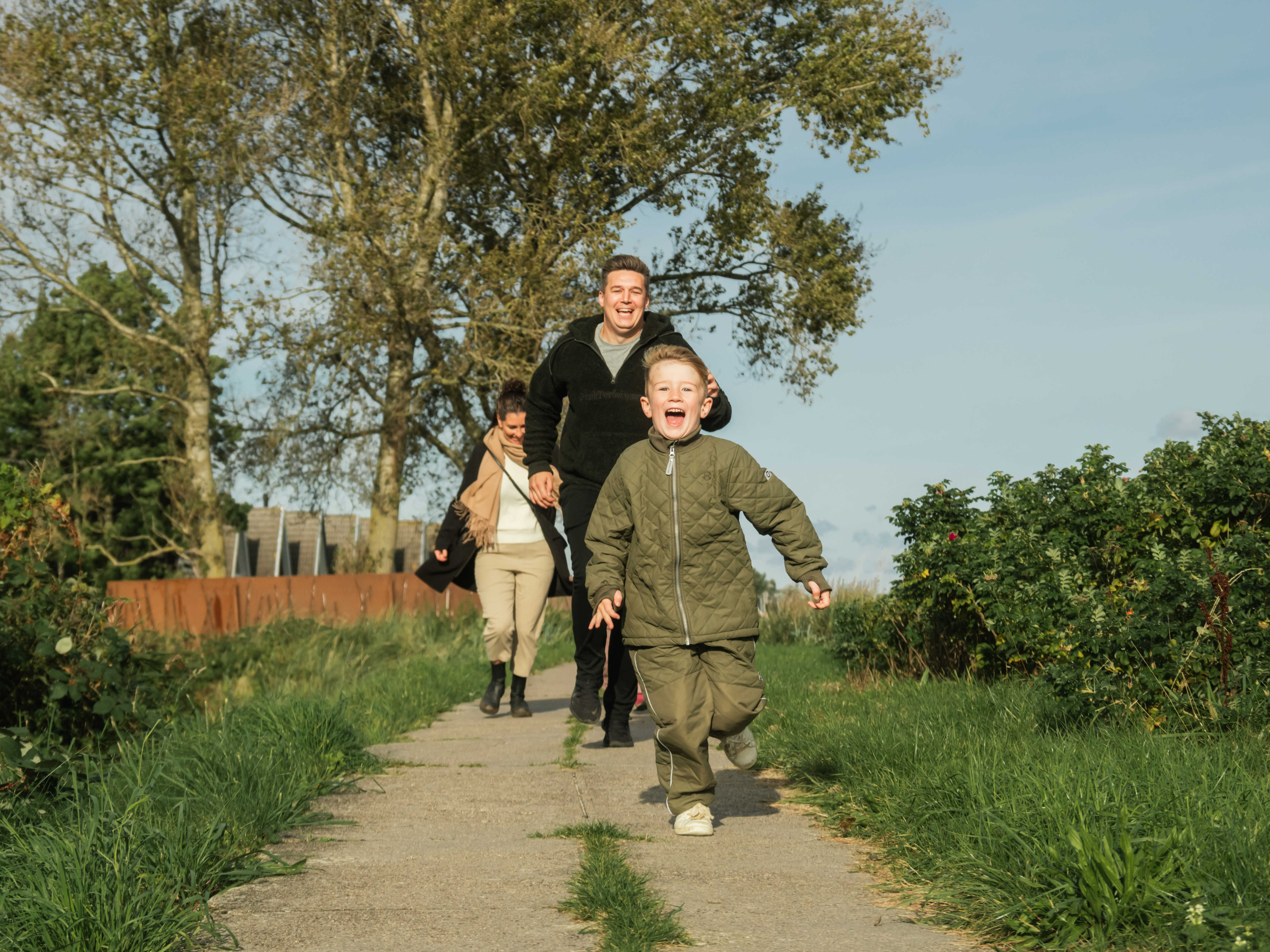 Familie med barn løber på sti