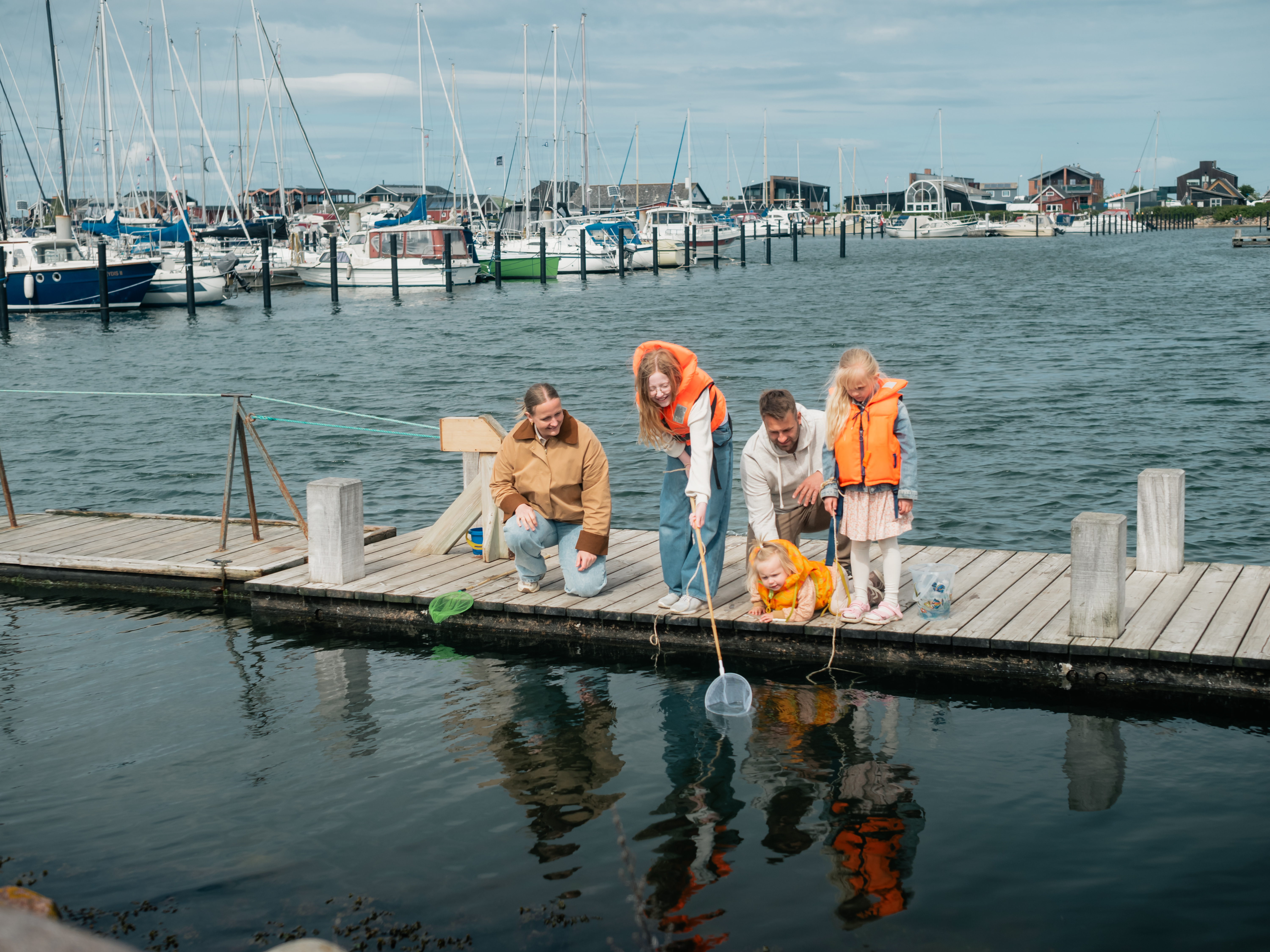 Familie, der fanger krabber ved Bogense Havn og Marina.
