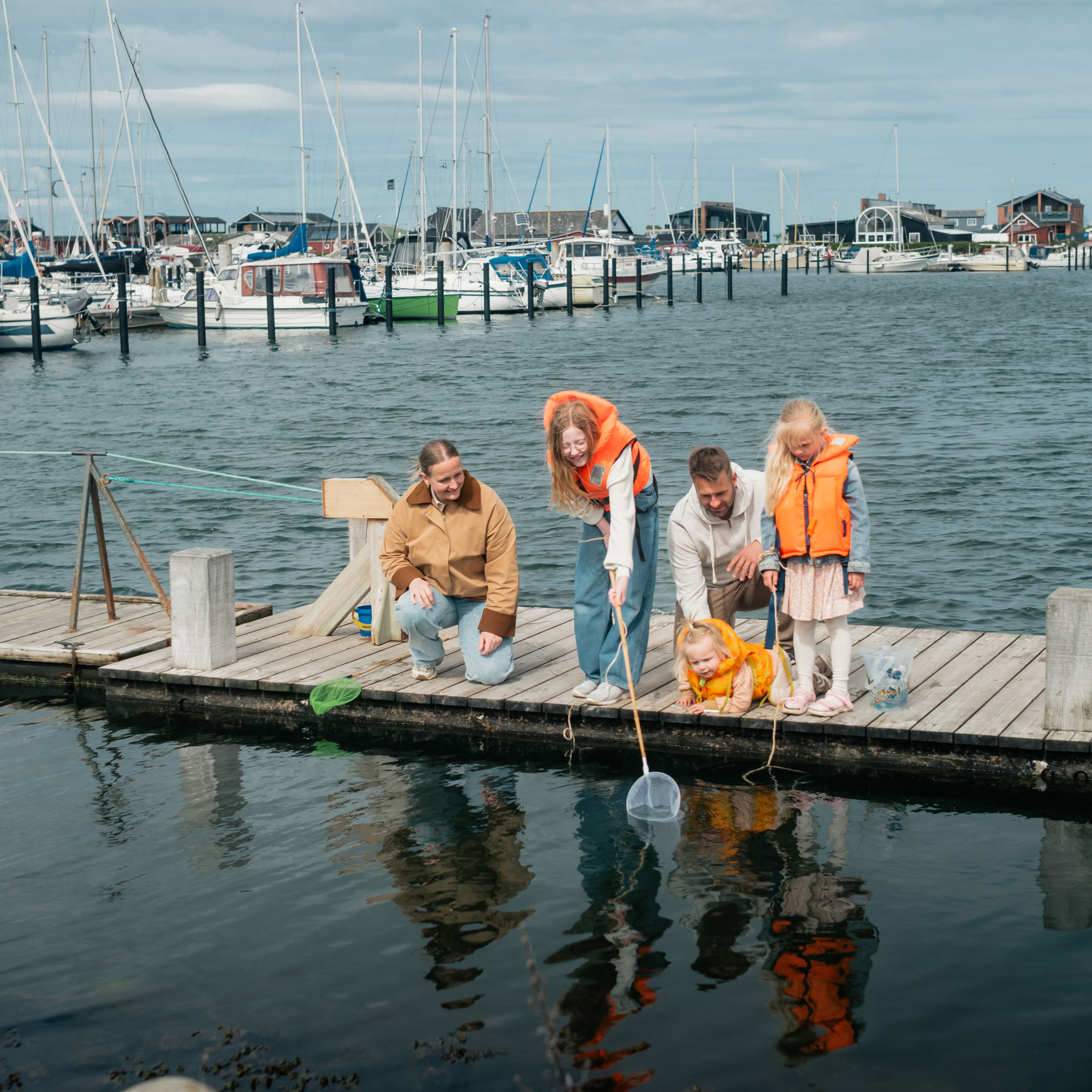 Familie, der fanger krabber ved Bogense Havn og Marina.