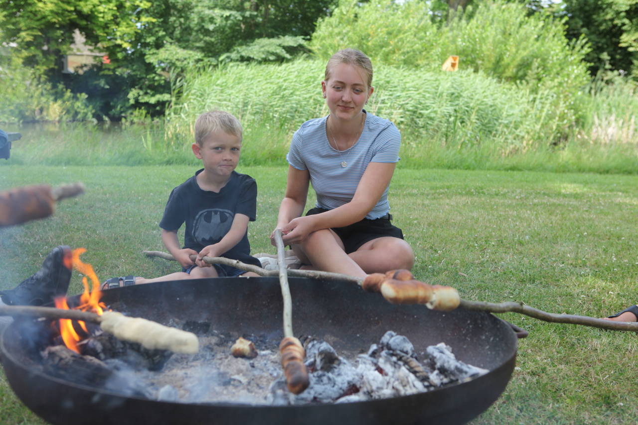 To børn, der bager snobrød ved gadekæret i Jullerup-Melby.