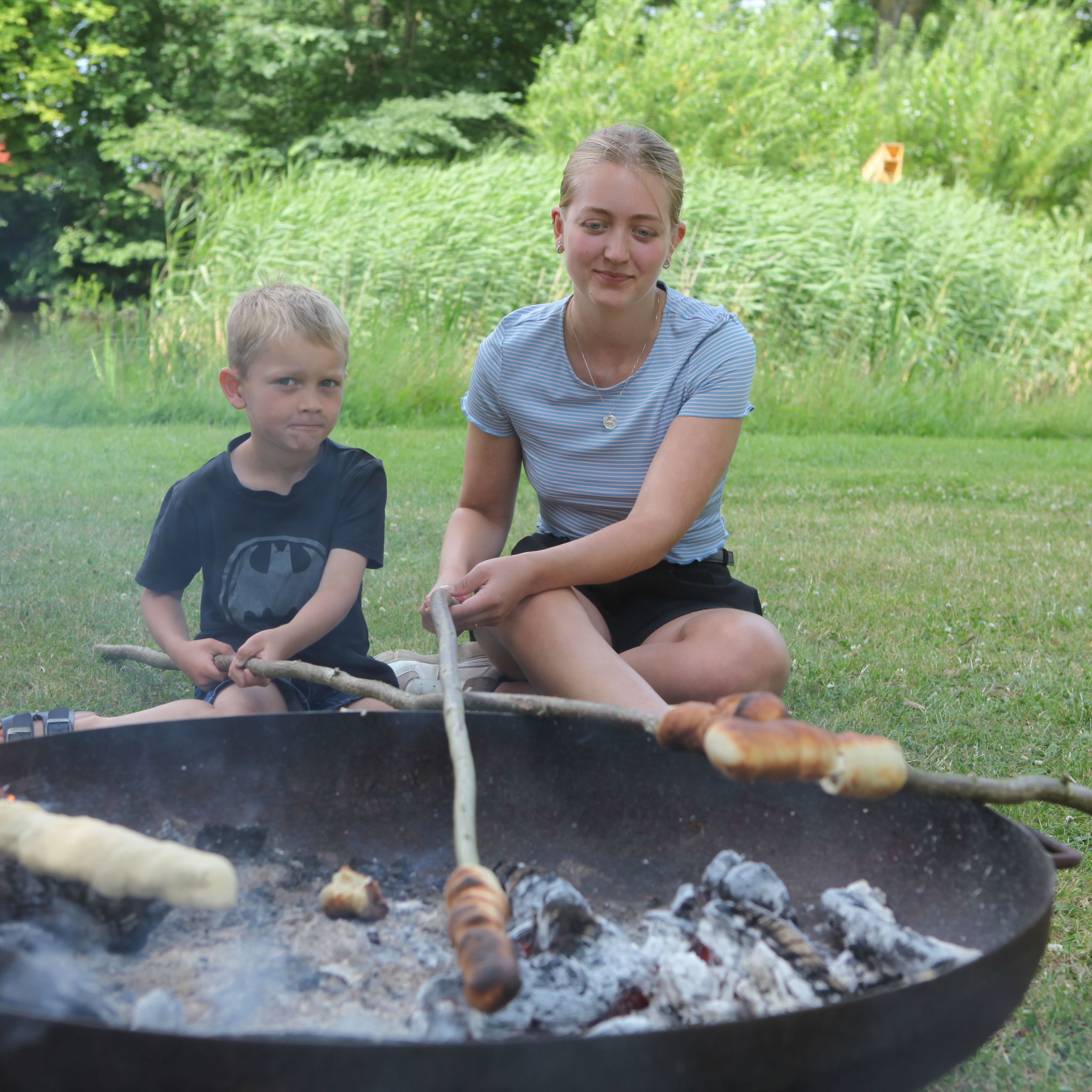 To børn, der bager snobrød ved gadekæret i Jullerup-Melby.