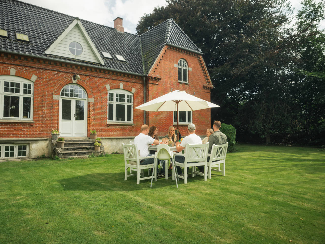 Vennepar, der mødes til kaffe i haven i Skamby.