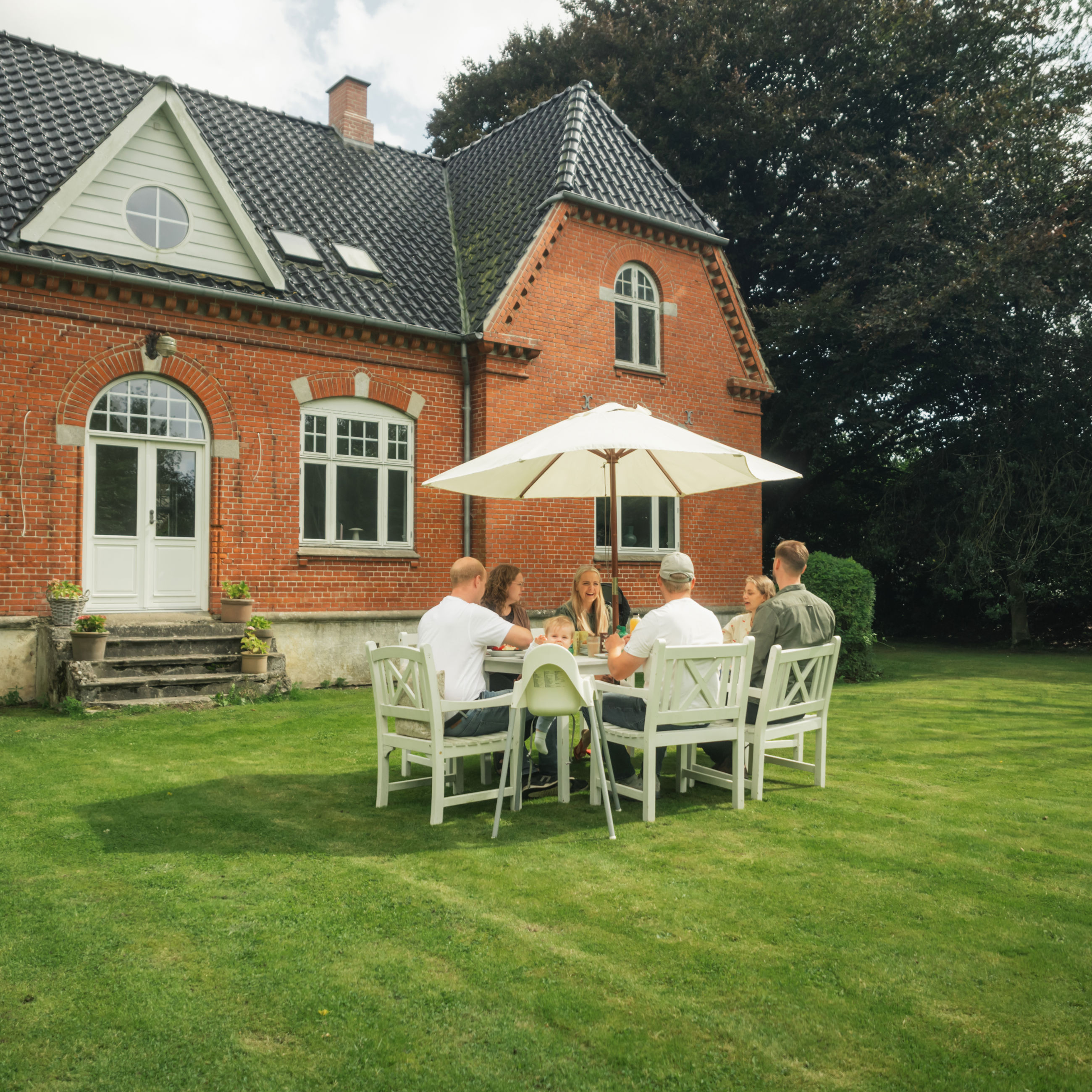 Vennepar, der mødes til kaffe i haven i Skamby.