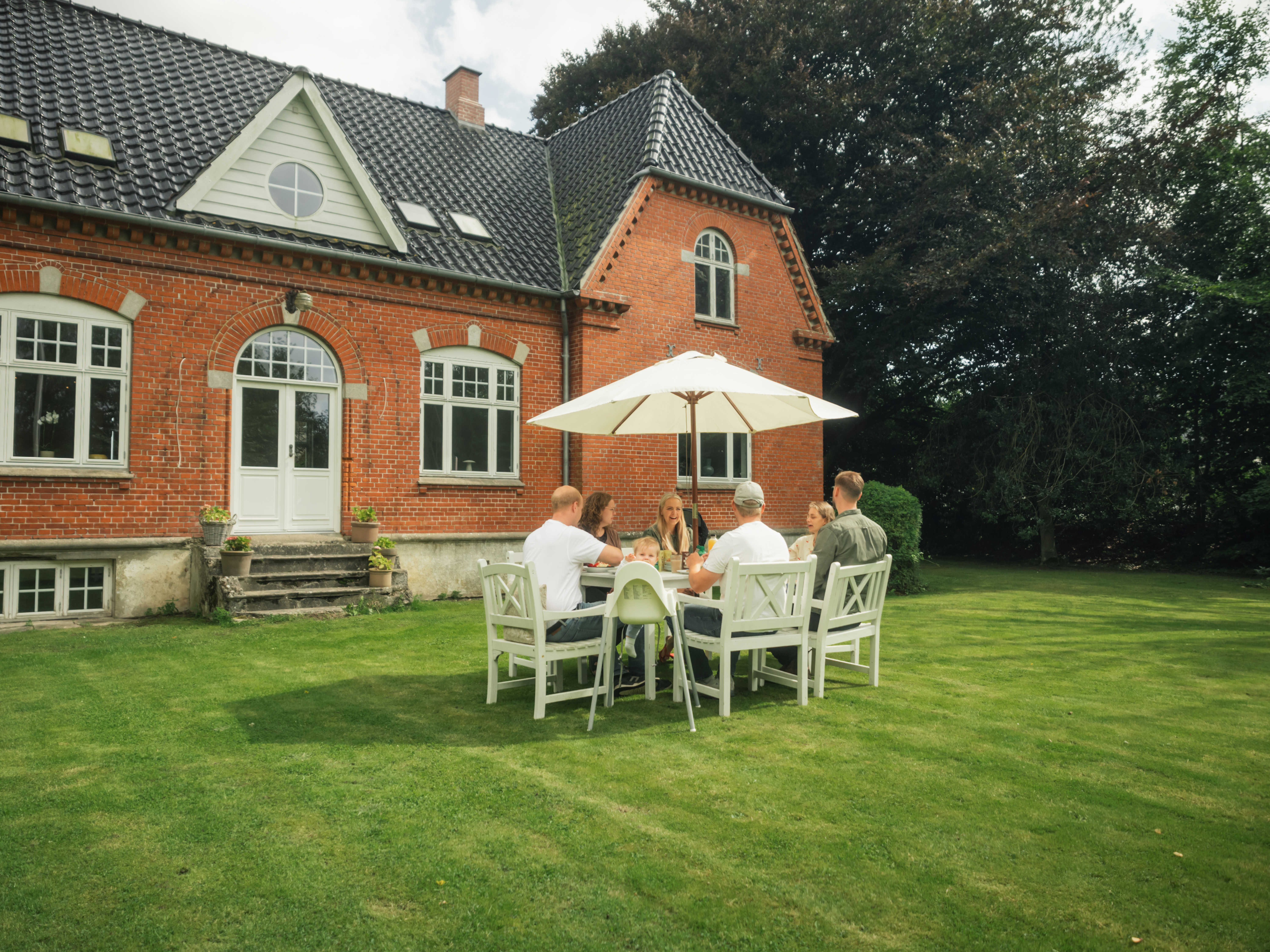 Vennepar, der mødes til kaffe i haven i Skamby.