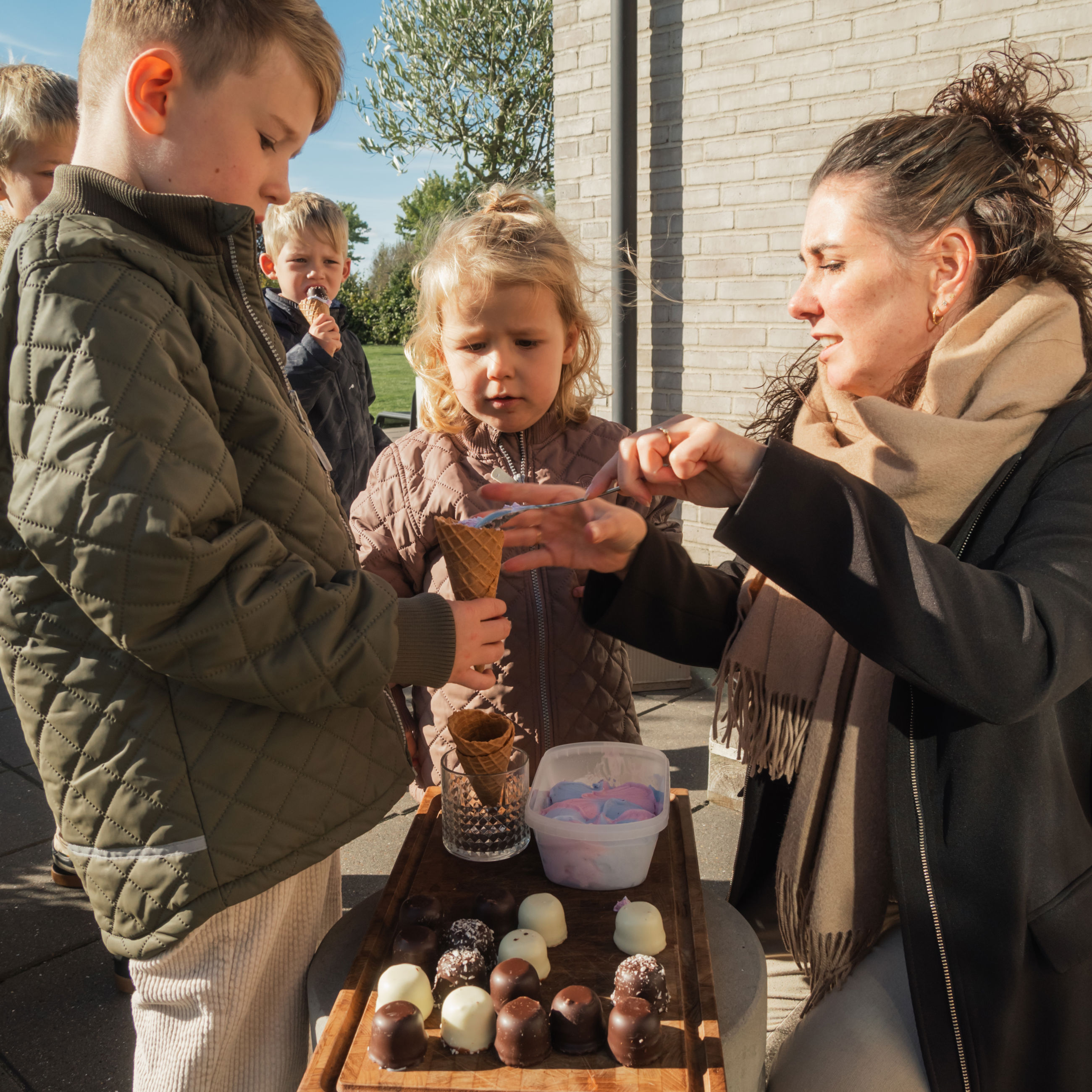 Billede af børn, der får hjemmelavede isvafler som snack i haven i et nybyggerkvarter i Otterup - efterår 2024.