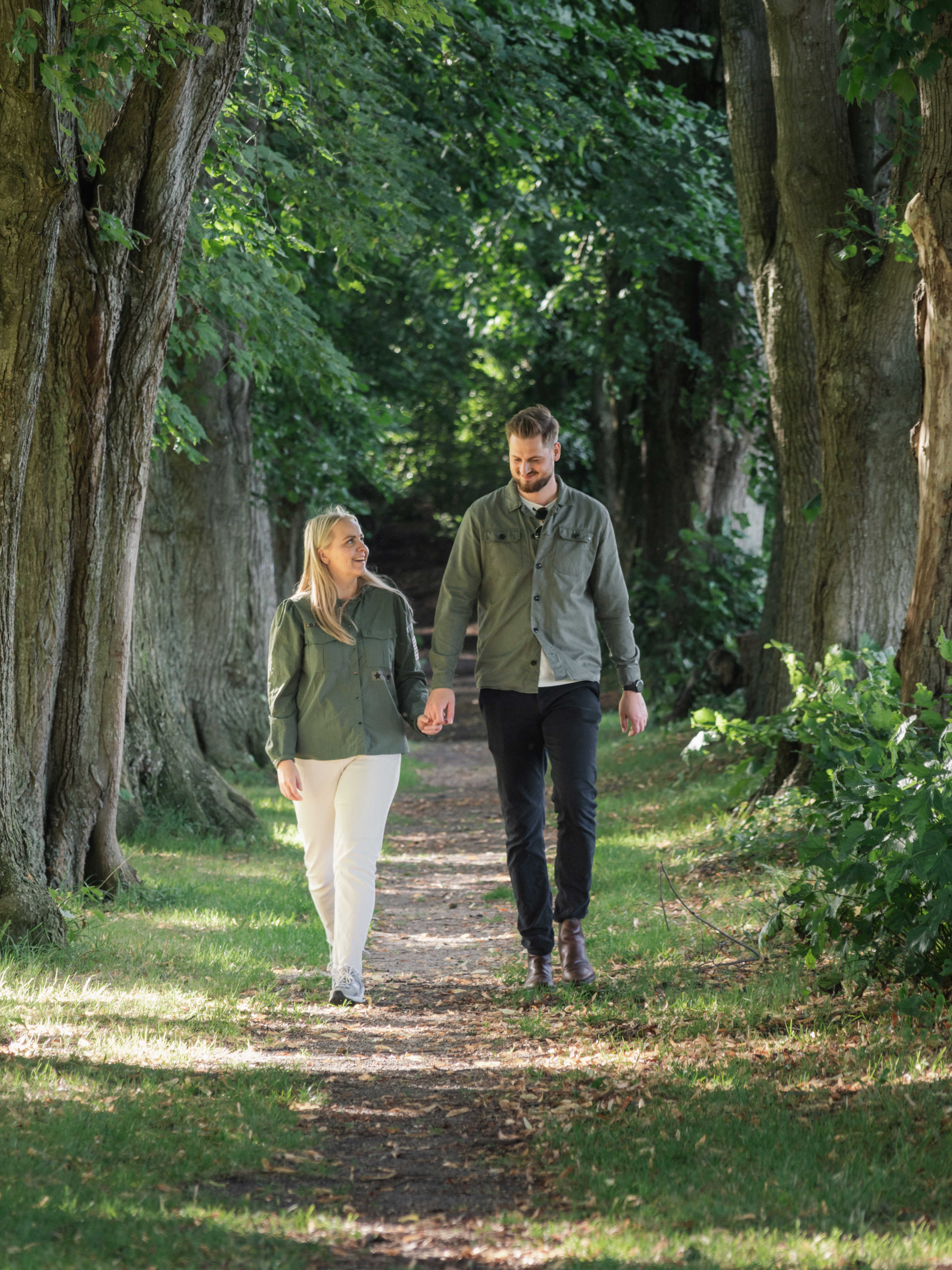 Par, der går hånd i hånd langs alléen i Glavendruplunden på Nordfyn.