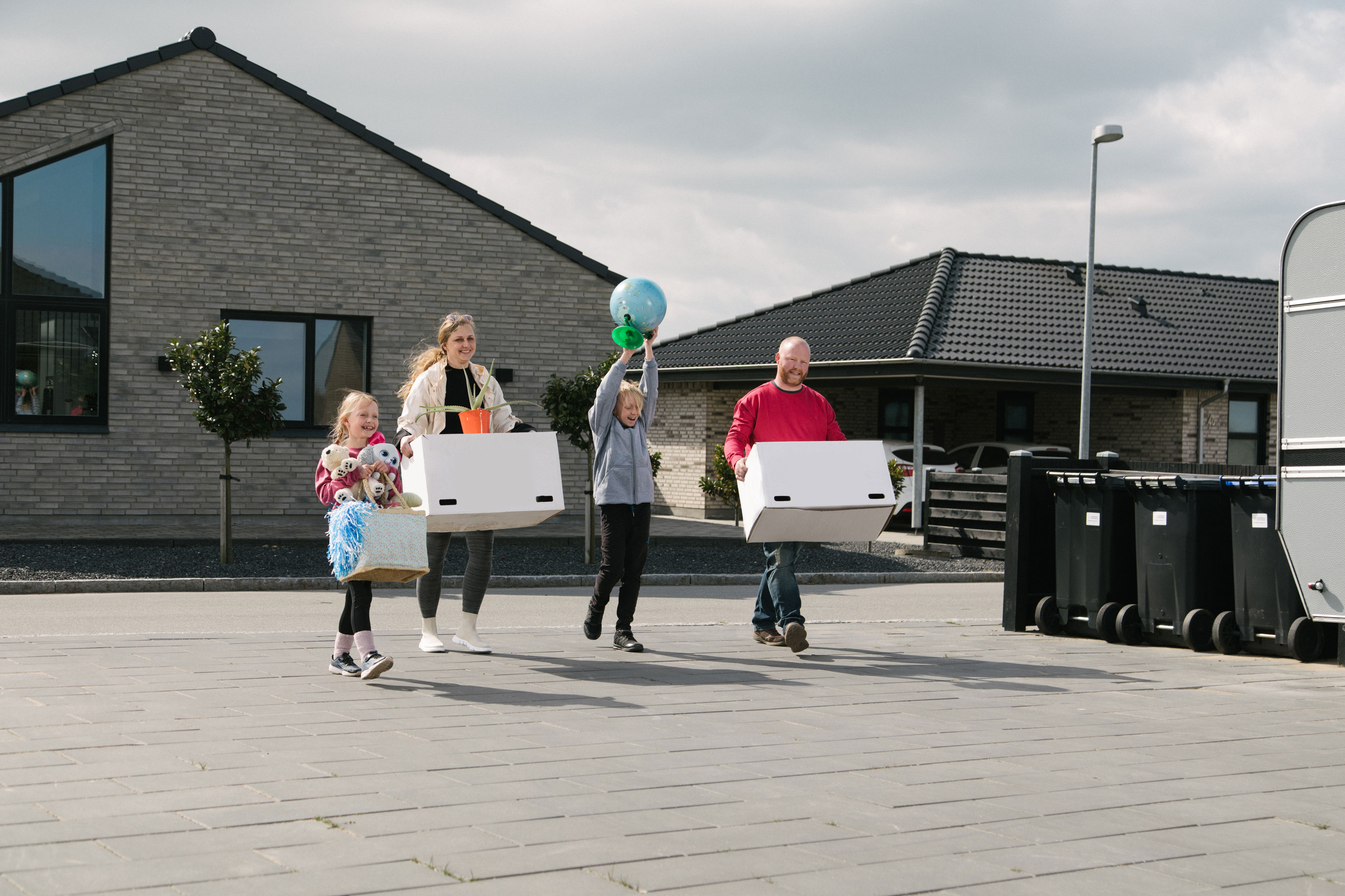 Familie med flyttekasser i nyt parcelhusområde