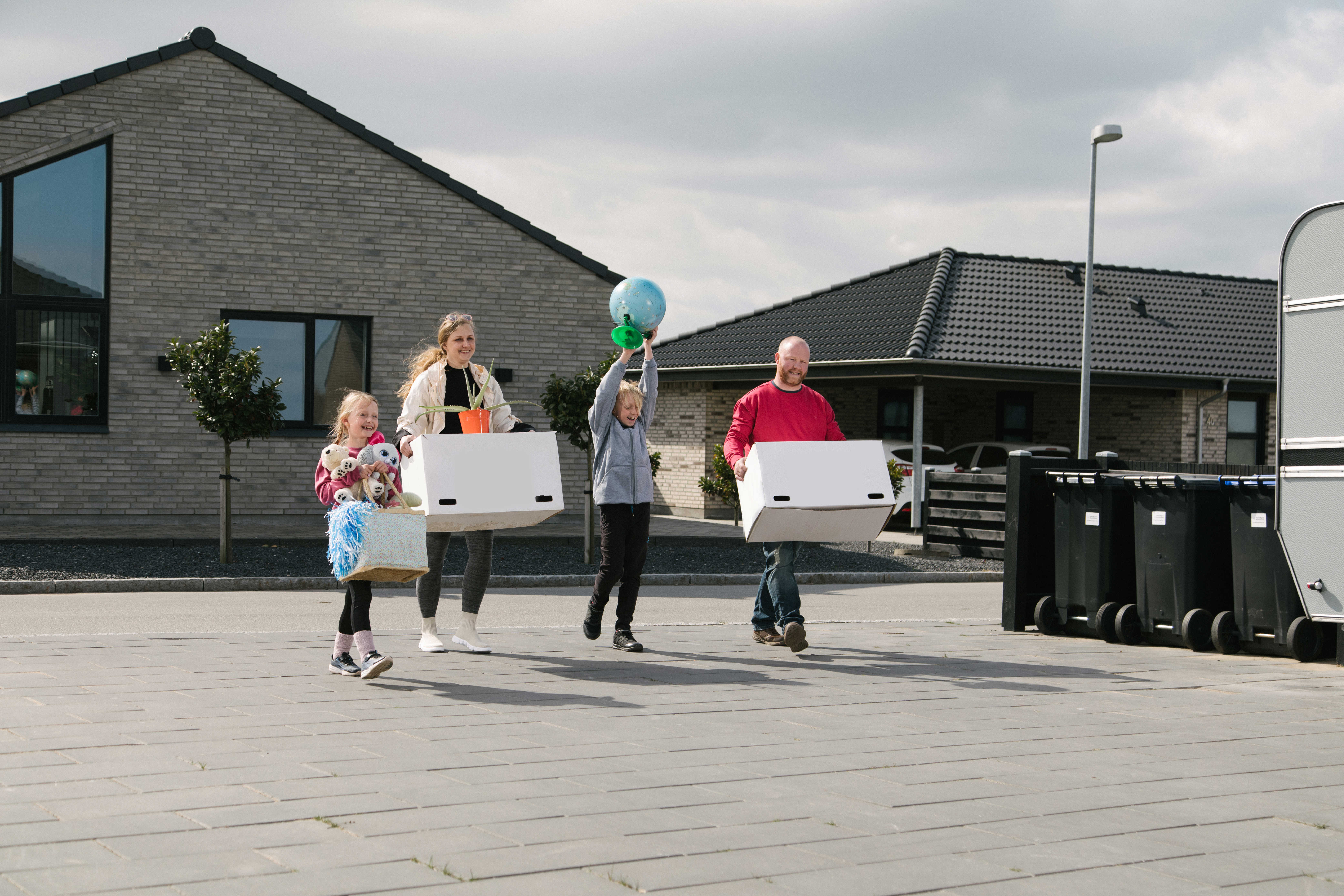 Familie med flyttekasser i nyt parcelhusområde